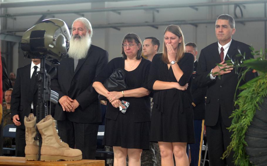 Emily Brainard, second from right, and family members stand before the fallen-soldier display honoring her husband, Capt. John "Jay" Brainard, and Chief Warrant Officer 5 John C. Pratt at a memorial service Tuesday in Ansbach, Germany. Brainard and Pratt were killed in a helicopter crash in Afghanistan on May 28.