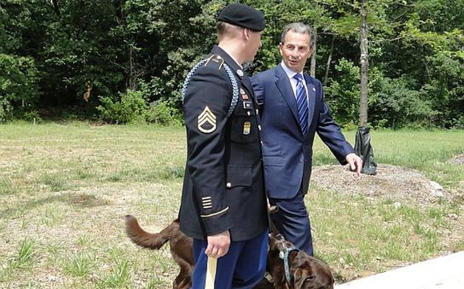 Staff Sgt. Christopher Milo, along with his service dog, Nemo, chats with Intrepid Fallen Heroes Fund Chairman Richard Santulli after the groundbreaking for a National Intrepid Center for Excellence satellite facility at Fort Belvoir, Va. Milo received brain injury treatment at the NICoE in Bethesda, Md.