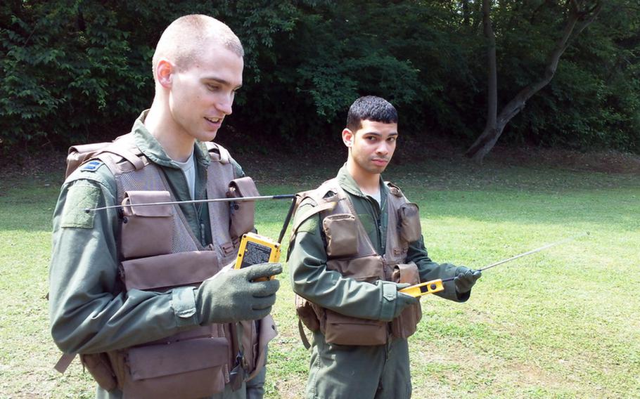 Capt. Stephen Jones, left, of Houston, and Airman 1st Class Giovanny Miranda, of Milwaukee, practice calling for help using radios at Tokyo's  Tama Hills Recreation Area last Thursday. The two were among airmen from Yokota Air Base, Japan, going through survival skills training.