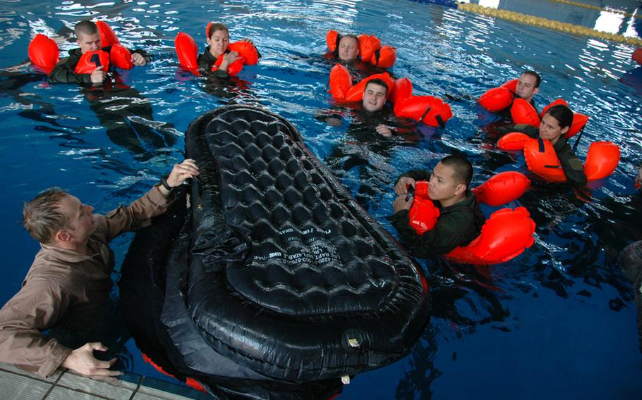 Staff Sgt. Robert Rogers, foreground left, of Waynesville, N.C., instructs flight crewmembers in water survival at Yokota Air Base, Japan, in April. Rogers is an Air Force Survive, Evade, Resist, Extract specialist with the 374th Operational Support Squadron.