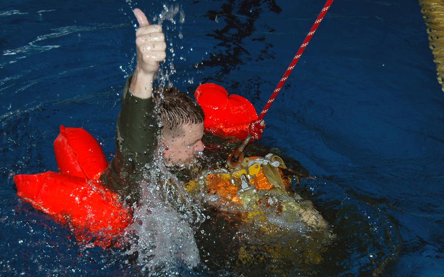 A member of the 374th Airlift Wing practices signaling to a helicopter crew that he's ready to be winched to safety during water survival training at Yokota Air Base, Japan, in April.