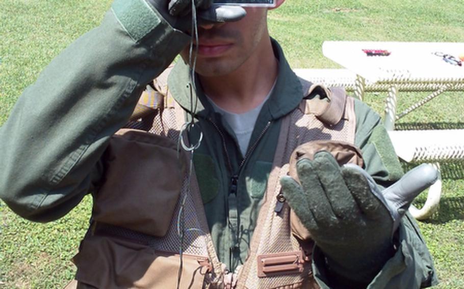 Airman 1st Class Giovanny Miranda, 21, of Milwaukee, Wis., uses a signal mirror during survival training at Tama Hills Recreation Area.