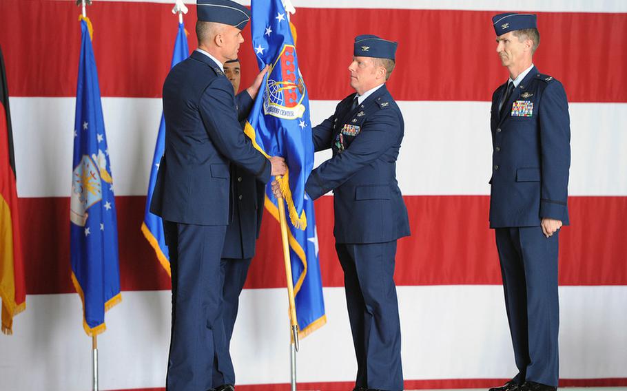 At the  603rd Air and Space Operations Center&#39;s change of command ceremony at Ramstein, Tuesday, 3rd Air Force commander Lt. Gen. Craig A. Franklin takes the unit&#39;s colors from outgoing commander  Col. Jeffrey L. Marker as incoming commander Col. Peter F. Davey, right, watches. Behind Franklin is Chief Master Sgt. Richard Zaferis.