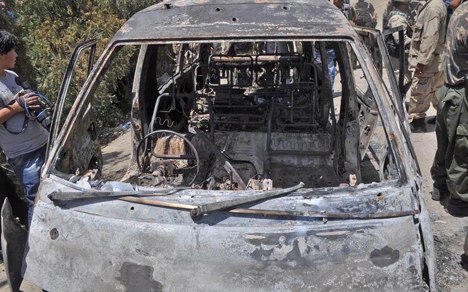The charred remains of a minivan parked at a lakeside resort near Kabul, where a 12-hour siege by militants that ended Friday morning left 18 people dead, among them 14 civilians.