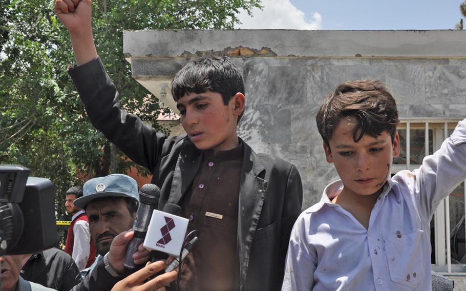 Two boys identified as hostages by Afghan security officials talk to reporters following the end of a 12-hour insurgent attack on a lakeside resort in Kabul that left 18 people dead.