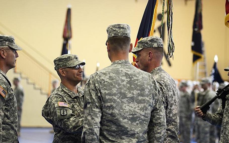 U.S. Army Col. Mark Raschke, incoming commander of the 170th Infantry Brigade Combat Team, passes the unit&#39;s colors to Command Sgt. Maj. James Ackerman during the change-of-command ceremony Tuesday at Smith Barracks in Baumholder, Germany. Maj. Gen. James Boozer Sr., deputy commander of U.S. Army Europe, left, and Col. Patrick Matlock, the outgoing commander of the 170th, were also part of the passing of colors that symbolizes the change of command.
