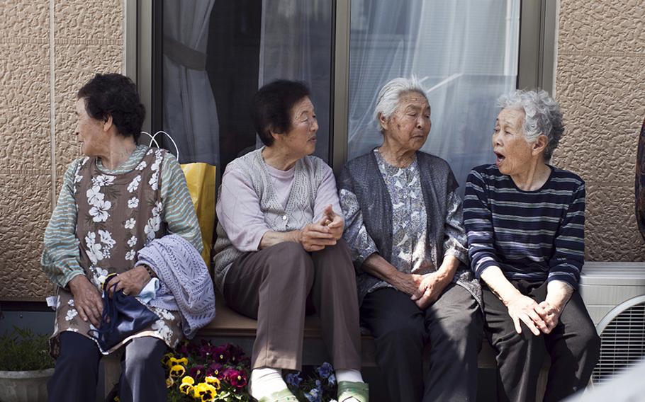 Women talk outside the common area at the Terauchi Dai-ni temporary housing area on June 2, 2012.