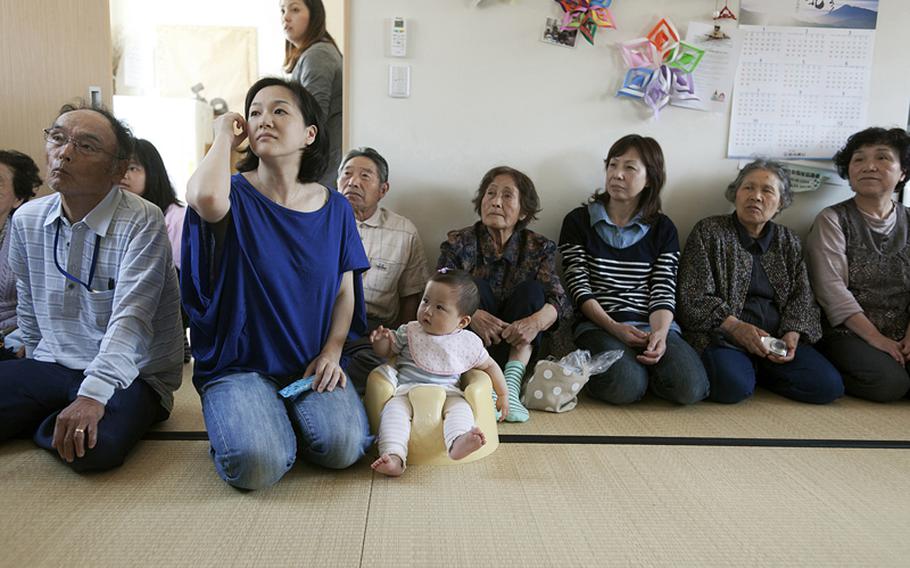 Kiho Ueno, second from left, has been living with her husband and daughter Sarii in temporary housing since the March 2011 tsunami, which killed her parents and two of her children. She longs to rebuild her former neighborhood but knows any house near the water would be isolated and at risk of another disaster.