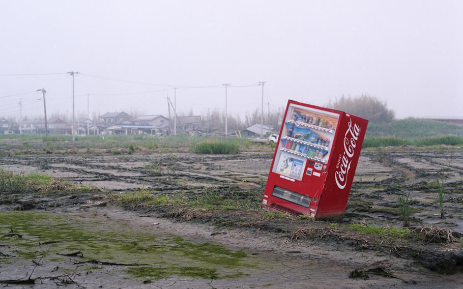 A vending machine, dragged inland during the March 2011 tsunami, still sits in a field in Minamisoma, Japan, 15 months later.