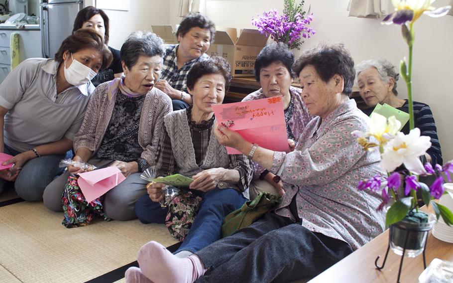 Residents of the Terauchi Dai-ni temporary housing area look at Mother&#39;s Day cards made and delivered by members of the military spouses organization Helping Hands for Tohoku on June 2, 2012.