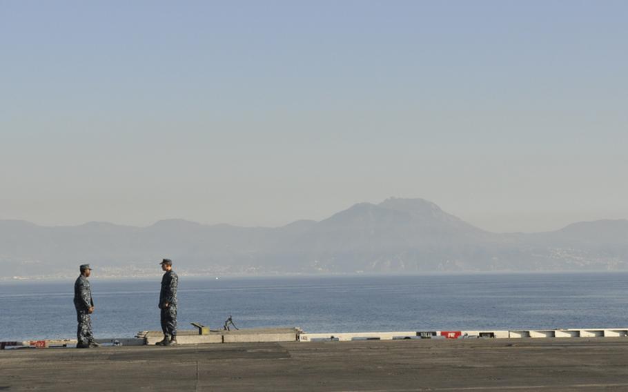 Sailors onboard the USS Enterprise chat within view of the Amalfi Coast’s picturesque cliffs. The ship docked in the Gulf of Naples before heading home to Virginia from its 25th and final deployment.