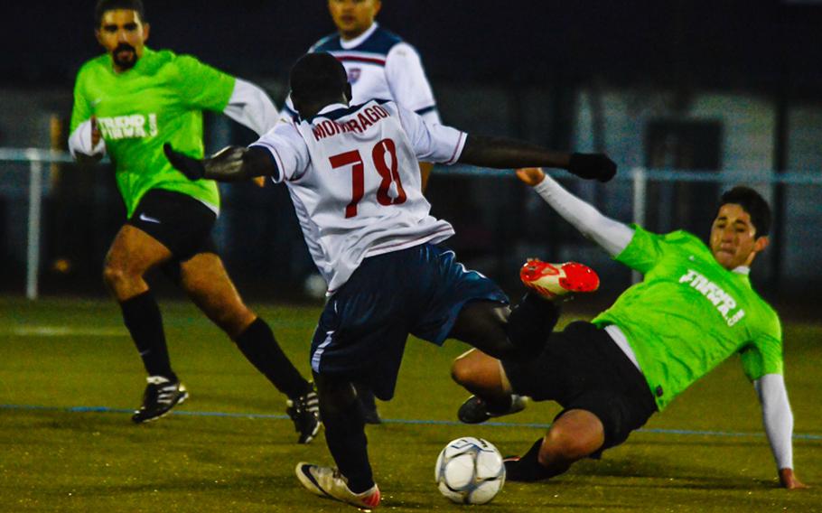 Vicenza's Jose Villareal takes a shot on goal as Ramstein's Everado Gomez tries to make a slide tackle at the U.S. Forces Europe soccer championship  in Wiesbaden, Germany, in October. Ramstein won the title after an overtime and a shootout.