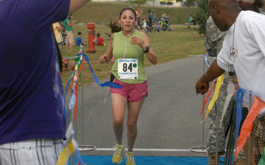 Sgt. Catalina Sandoval, 25, of the 57th Signal Company, crosses the tape as the first female finisher in the U.S. Forces-Europe Army Ten-Miler in Grafenwohr, Germany in June. Sandoval, who finished with a time of 69 minutes, 5 seconds, qualified to represent U.S. Army Europe at the Army Ten-Miler in Washington, D.C. in October.