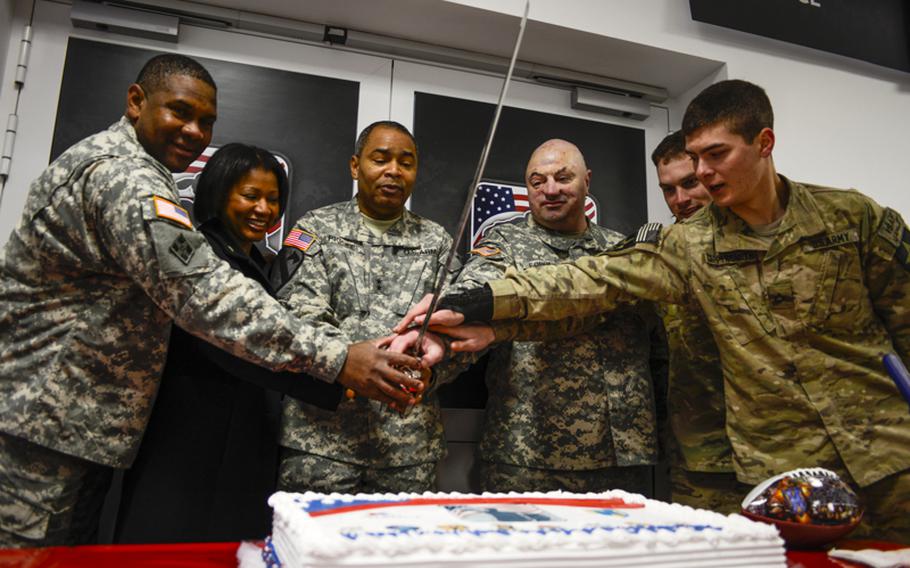 From left, U.S. Army Col. Fred Hannah, AAFES Europe-Southwest Asia commander;  Kassi Piggee, wife of Maj. Gen. Aundre Piggee, commander of the 21st Theater Sustainment Command; Piggee; and wounded warriors Staff Sgt. Josh Forbess, Spc. Scott Franklin and Pfc. Tyler Coppersmith prepare to cut the cake at the grand opening Wednesday, Jan. 16, 2013,  of the Wounded Heroes Service Center on Kleber Kaserne in Kaiserslautern, Germany.