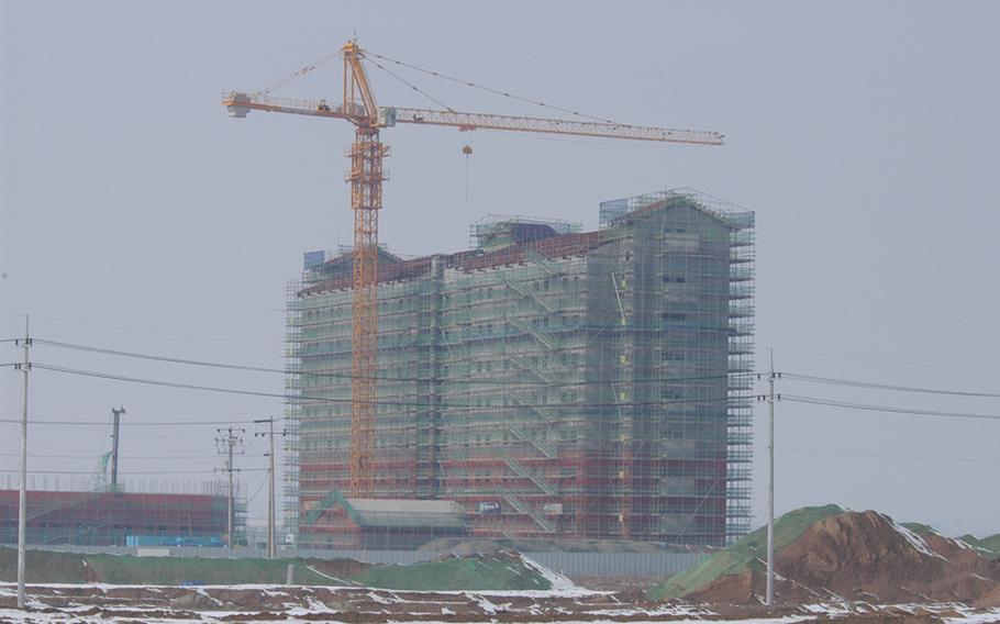 One of several buildings under construction is visible in the distance from the central commercial area of Camp Humphreys, South Korea, in 2013. 