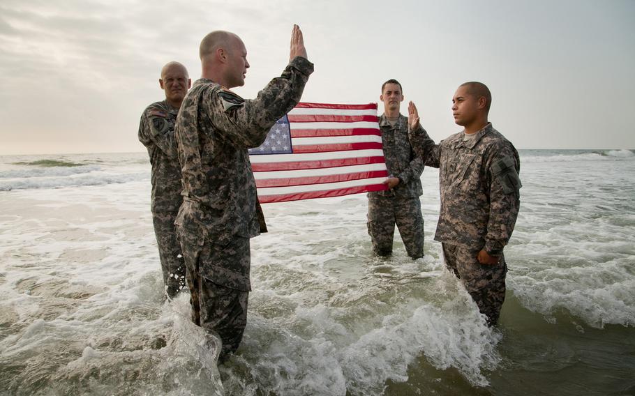 US Army Sergeant David Milne, 3rd Military Information Support Battalion (Airborne), re-enlists amidst crashing waves in the Atlantic Ocean, in Wilmington, N.C., on April 30, 2012.