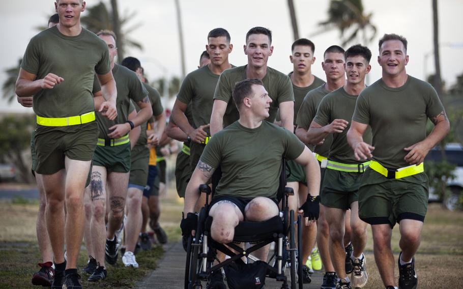 U.S. Marine Cpl. Garrett Carnes, in wheelchair, a squad leader with 3rd Platoon, India Company, 3rd Battalion, 3rd Marine Regiment, jokes with Sgt. Kenney Clark, right, during a motivational run held at Marine Corps Base Hawaii, on May 29, 2012. Carnes lost his legs in an improvised explosive device attack Feb. 19 while supporting combat operations in the Khan Neshin district of Afghanistan??s Helmand province.