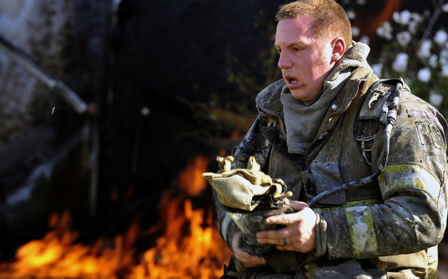 A Prince George's County firefighter takes off his self-contained breathing apparatus mask after fighting a house fire March 29, 2012 at Joint Base Andrews, Md.
