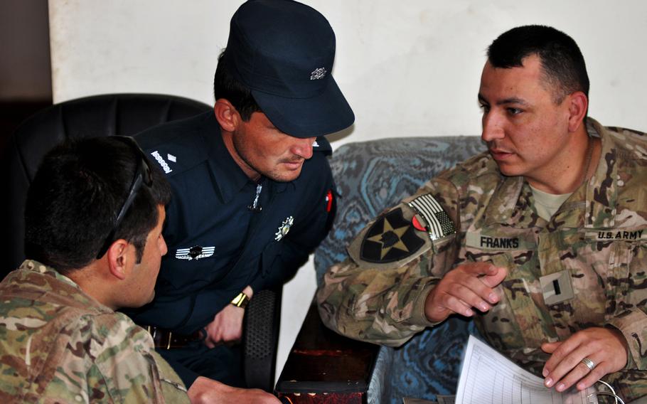 First Lt. James Franks, right, an adviser with a Security Force Assistance Team, and an interpreter, help Afghan Uniformed Police officer Jamil Kootwall, center, fill out requisition forms at the Spin Boldak District Police Center.