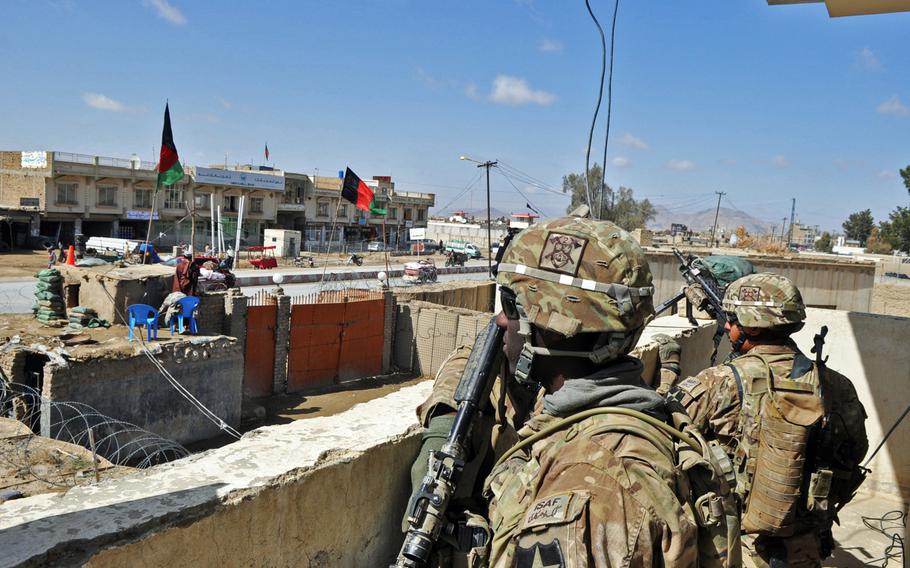 Pfc Marius Keith, left, and Spc. Chris Castro provide security at the District Police Center in Spin Boldak, Afghanistan. American teams make the rounds to police stations to train officers to develop staff-level capabilities like planning, logistics and personnel.
