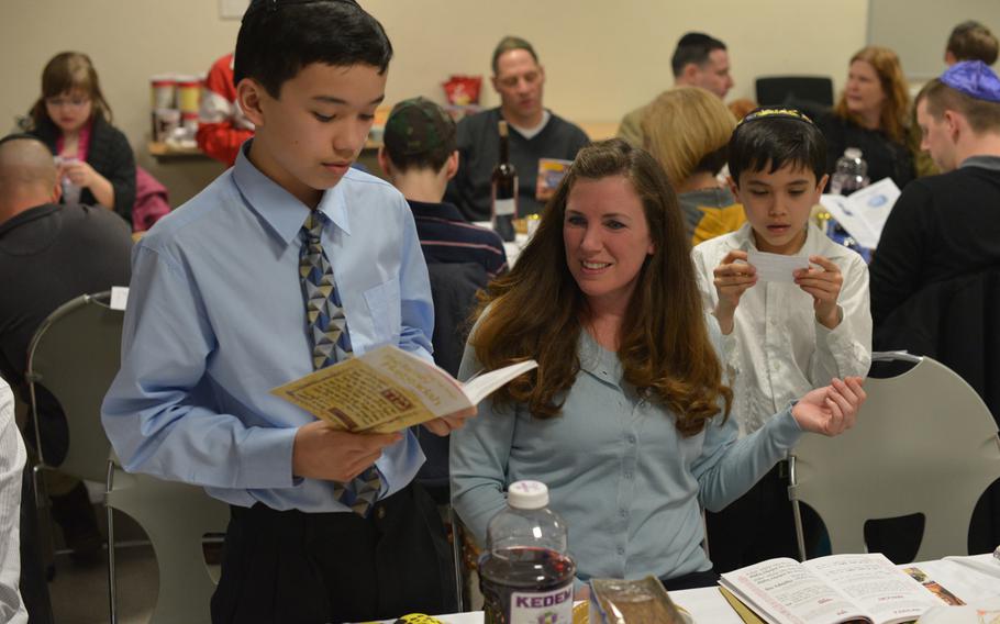 Jesse Juan, 12, left, and his brother Braden, 8, read during Monday's Passover Seder in Grafenwohr, Germany, as their mother, Natalie, 40, looks on. Some 50 people attended the first of four Seders held by U.S. Army Europe's only Jewish chaplain, Capt. Andrew Shulman.