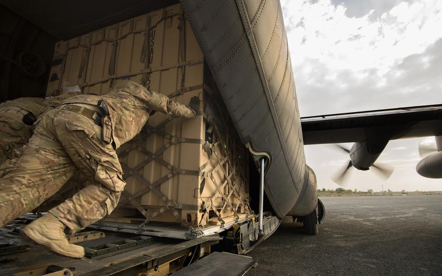 Staff Sgt. Daniel Hall, along with other 19th Movement Control Team aerial porters muscle a shipping container into a 774th Expeditionary Airlift Squadron C-130 Hercules cargo plane at Forward Operating Base Salerno, Khost province, Afghanistan, Sept. 22, 2013.