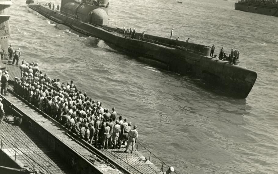 U.S. Navy sailors watch the I-400 roll past in Japanese waters at the end of World War II.