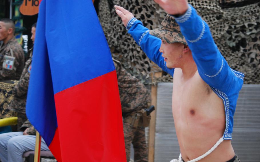 A Mongolian soldier based at Camp Marmal in Mazar-i-Sharif, Afghanistan, celebrates a win after a wrestling match on the Mongolian contingent's camp. The Mongolians invited their coalition partners to celebrate the Lunar New Year with them.