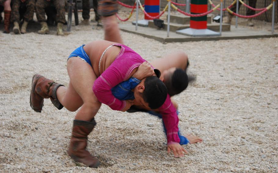 Two soldiers with the Mongolian Armed Forces contingent based at Camp Marmal in Mazar-i-Sharif, Afghanistan, wrestle in their annual Lunar New Year tournament, Jan. 31, 2014. The Mongolian contingent invited their coalition counterparts bring in the new year with them.