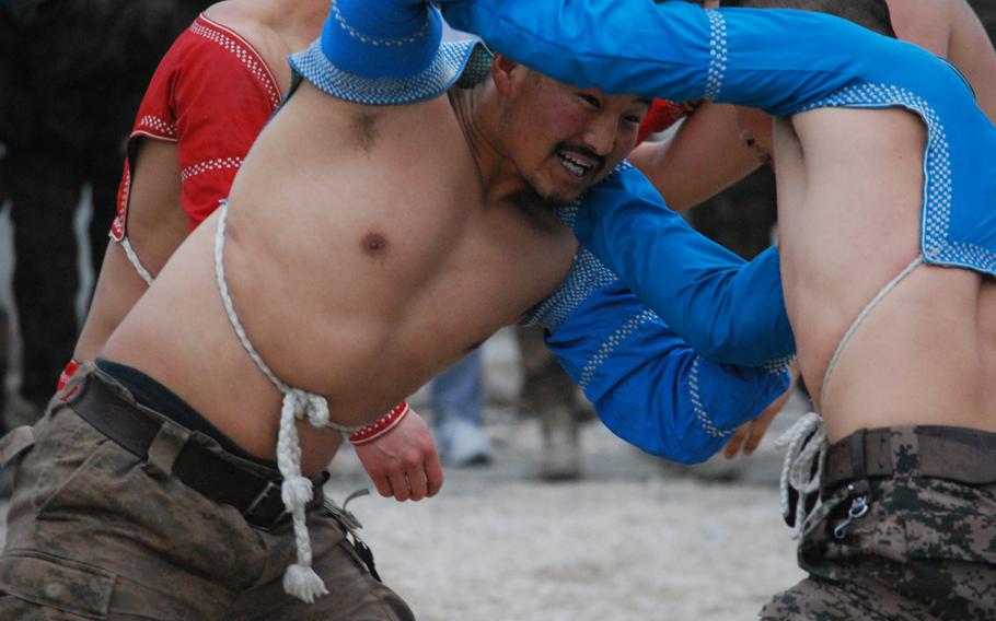 Two soldiers with the Mongolian Armed Forces contingent based at Camp Marmal in Mazar-i-Sharif, Afghanistan, wrestle in their annual Lunar New Year tournament, Jan. 31, 2014. Wrestling, a popular tradition in Mongolian culture, is used to bring in their new year. 