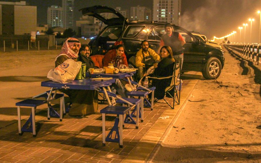 A group of local residents had a barbecue in the early morning hours of Jan. 31, 2014, alongside the shutdown Prince Khalifa Bin Salman Causeway to watch workers move an approximately 400-foot long tied-arch suspension flyover bridge across the roadway.