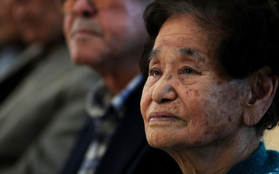 Masako ''Iha'' Sunabe, the older sister of the photo album's original owner, Mitsuko, listens to comments from Carolyn Wieden, widow of Francis ''Duke'' Weiden, the sailor who found Mitsuko's album in 1945, during a ceremony in Chatan, Okinawa, Jan. 12, 2014.