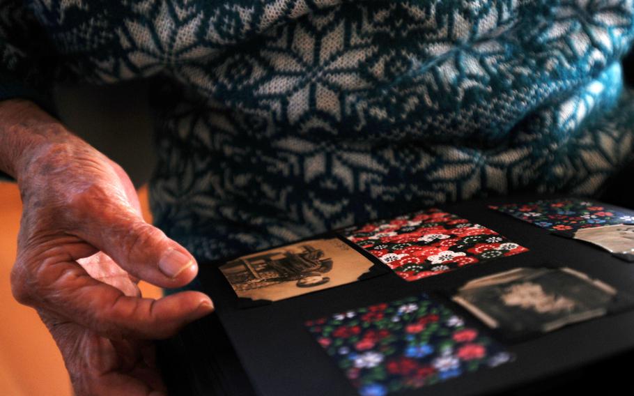 Masako "Iha" Sunabe browses through her sister's photo album, recalling faces and memories from almost 70 years ago in Chatan, Okinawa, Jan. 12, 2014. 