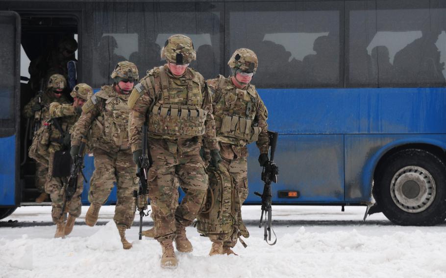 Soldiers from the 2nd Brigade Combat Team, 101st Airborne Division, get off a bus and walk toward a C-17 transport plane at Mihail Kogalniceanu Air Base in Romania on  Feb. 3, 2014. The soldiers represented the first wave of passengers to transit through the base en route to a mission in Southwest Asia.