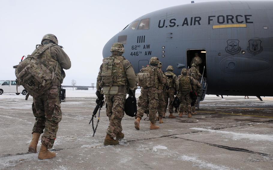 Soldiers from the 2nd Brigade Combat Team, 101st Airborne Division, walk toward a C-17 transport plane on Mihail Kogalniceanu Air Base in Romania on Feb. 3, 2014. The soldiers were departing for a deployment in Afghanistan.