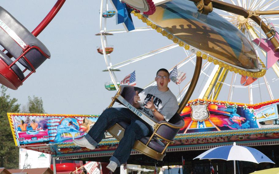A visitor to the 2005 German American Volksfest in Hohenfels, Germany, signals his enthusiasm for The Twister, a popular carnival ride. After being canceled last year due to budget constraints, the popular community festival and the one in Grafenwöhr are slated to take place again in 2014. 