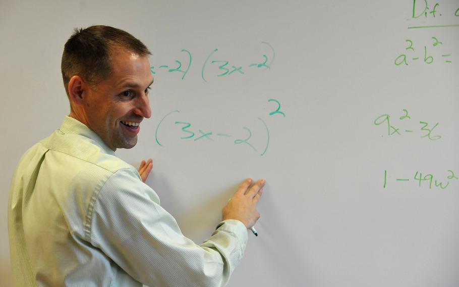 Ramstein High School teacher Spencer Bean goes over algebra problems with students in his "flipped mastery" algebra class.