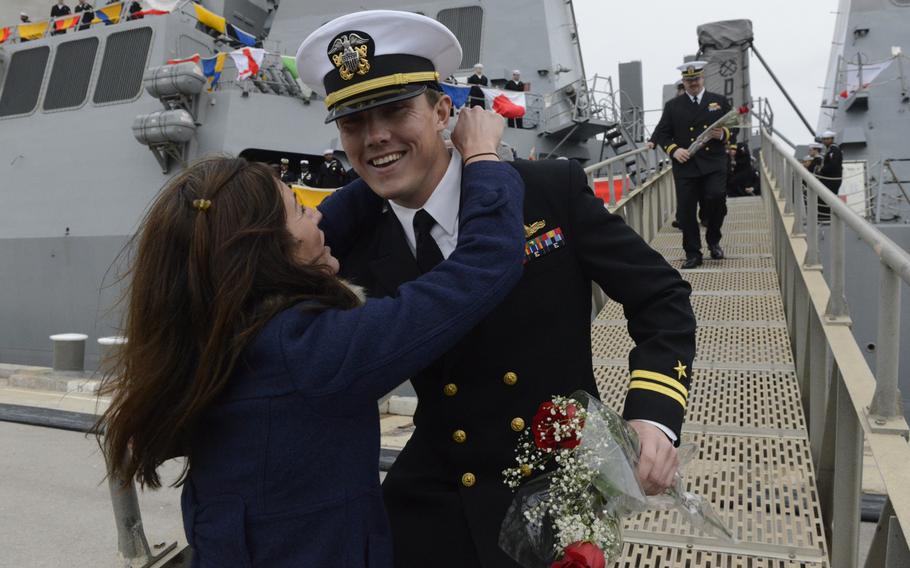 An officer assigned to the guided-missile destroyer USS Donald Cook is greeted at the gangplank as the ship arrives in Rota, Spain, on Tuesday, Feb. 11, 2014. 