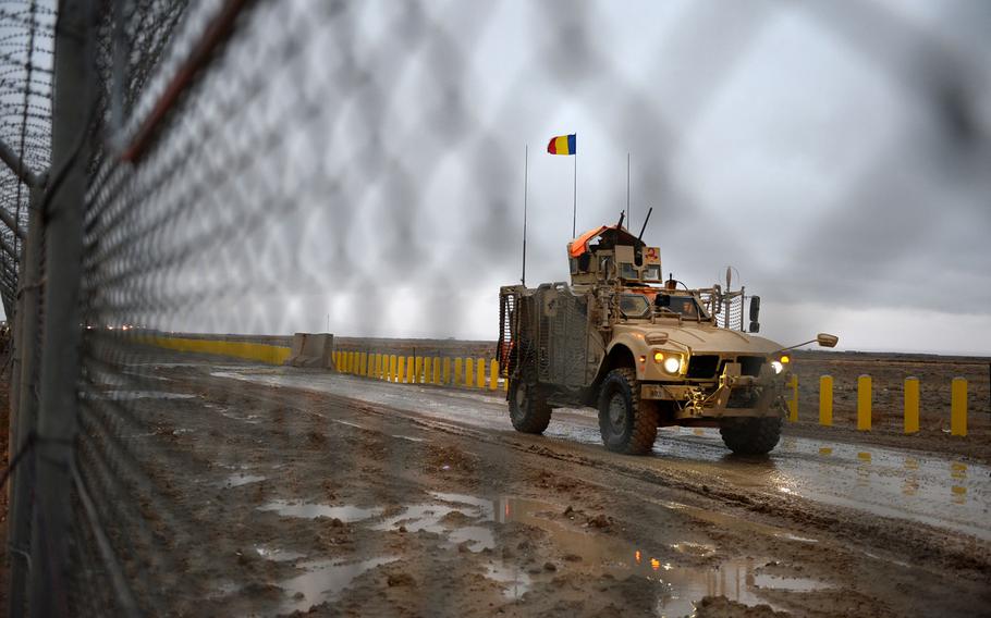 A Romanian vehicle drives just outside Kandahar Air Field, Afghanistan. Days of rain and snow have turned unpaved ground to cold mud.