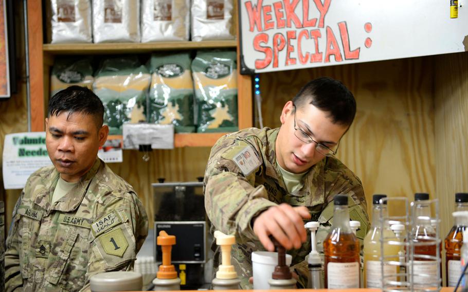 Staff Sgt. Arnelle Aguada, left, and Spc. Andrew Rivas make coffee for soldiers coming in from the cold at The First Cup, a volunteer coffee bar next to the flight line at Kandahar Air Field, Afghanistan. Asked his opinion of the weather, Rivas asked, "Is that a joke?"