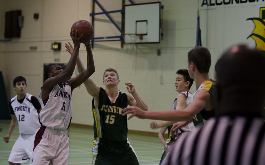 AFNORTH's Jacquon Sinclair vies for the ball with Pavel Karamshin of Alconbury, during a game Saturday, Jan. 18, 2014, at the Alconbury Middle/High School in England. The school's gym is closed until at least Thursday after a portion of the roof was blown off in severe weather over the weekend.