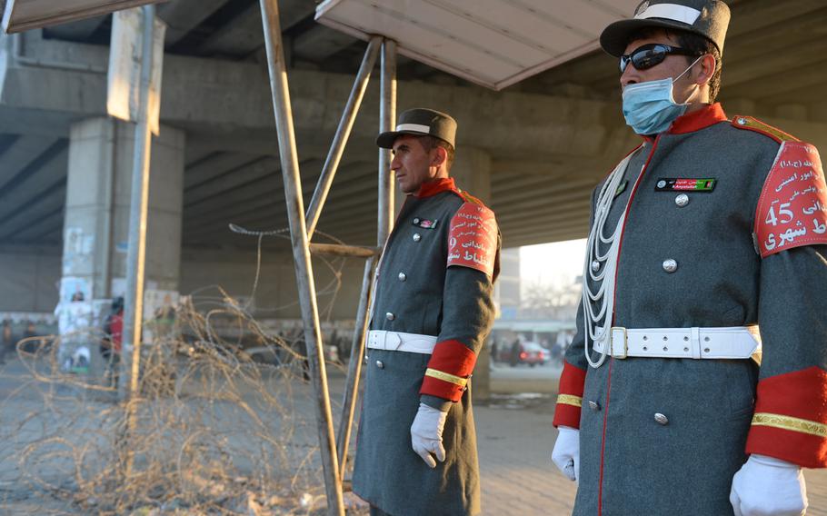7:18 a.m. Inzebat-e Shahri (City Discipline) police officers stand at attention under Afghanistan's only highway overpass in western Kabul. Inzebat-e Shahri officers are placed at busy intersections around the city to showcase the professionalism of the Kabul police.