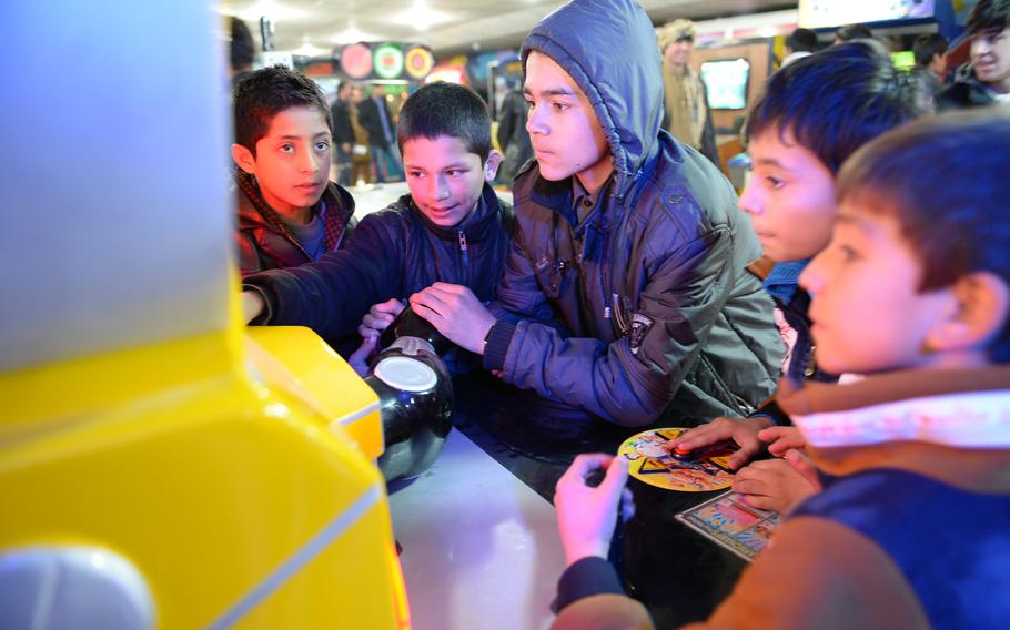 12:35 p.m. Children play video games at an arcade in the Gulbahar Center mall. 