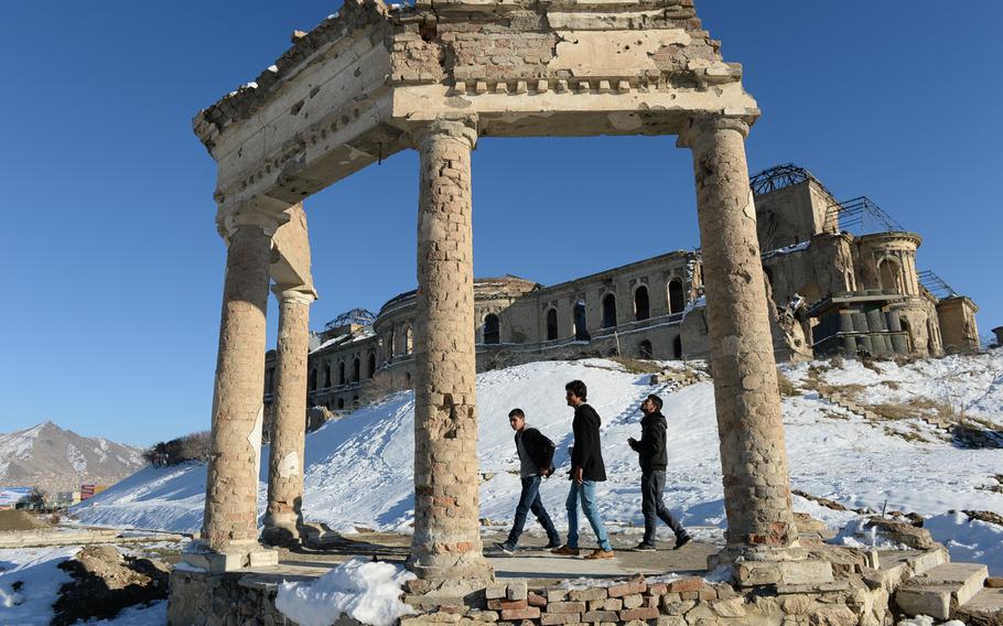 4:08 p.m. Young men walk the grounds of Darulaman Palace in west Kabul. 
