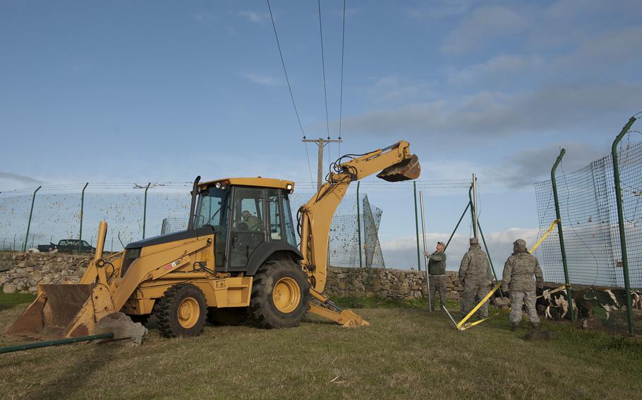 Airmen from the 65th Civil Engineer Squadron help to install a fence on Saturday, Feb. 15, 2014, at Lajes Field, Azores. Strong winds damaged 800 feet of base fencing and caused about $75,000 in damage. 

Paul Villanueva II/U.S. Air Force