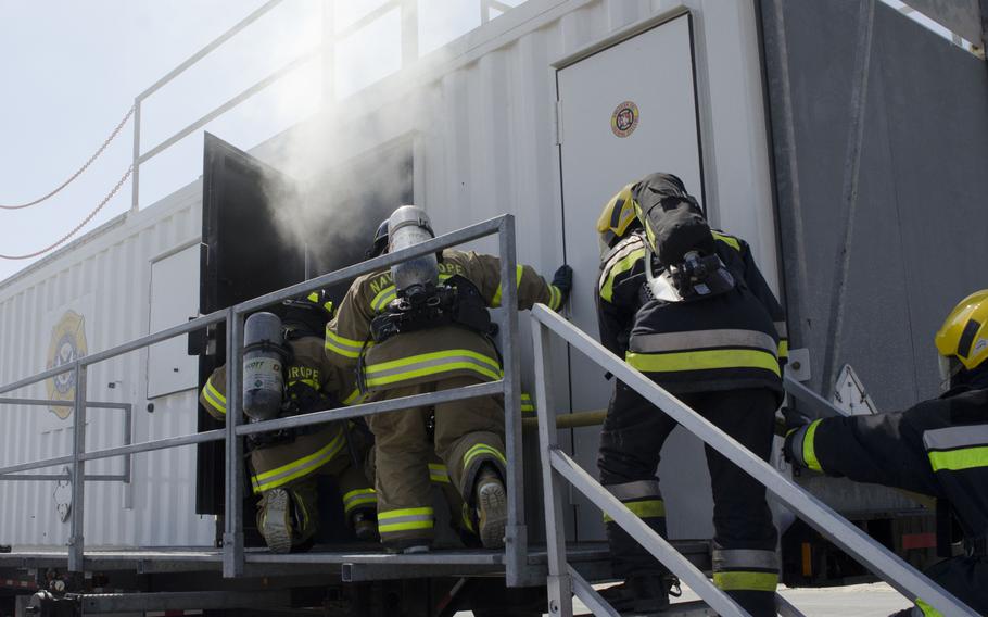 Firefighters from Naval Support Activity Bahrain and the Bahrain Airport Co. enter the new live structural fire training facility at Bahrain International Airport during an exercise. A complete fire training complex is planned at the site that will include classrooms and several trainers.