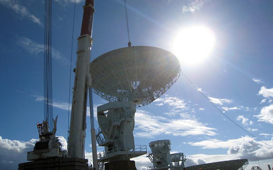 Workers lift an antenna dish onto its pedestal during construction of the Mobile User Objective System ground site in Niscemi, Sicily, in January 2014. The next-generation communication system is designed to provide secure, cellular-like voice and data signal to military networks and troops worldwide. 