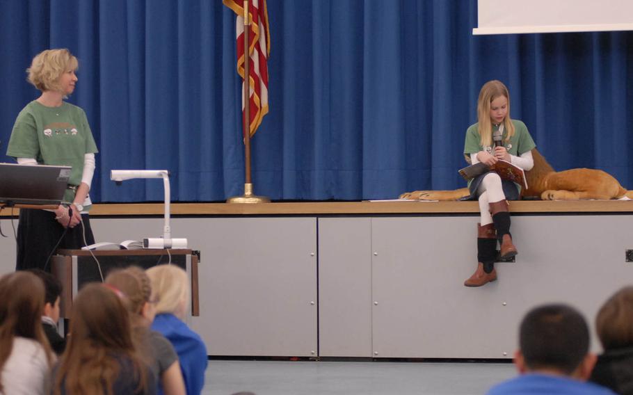 Ramstein Intermediate School fourth-grader Grace Anne Remey reads from her self-published book, "Lion's Pride on the Move," during the school's celebration Monday of "Read Across America Day." Organized by the National Education Association, "Read Across America Day" is designed to promote reading among children and young adults. Looking on is Grace's mom, Lisa Remey.

Jennifer H. Svan/Stars and Stripes