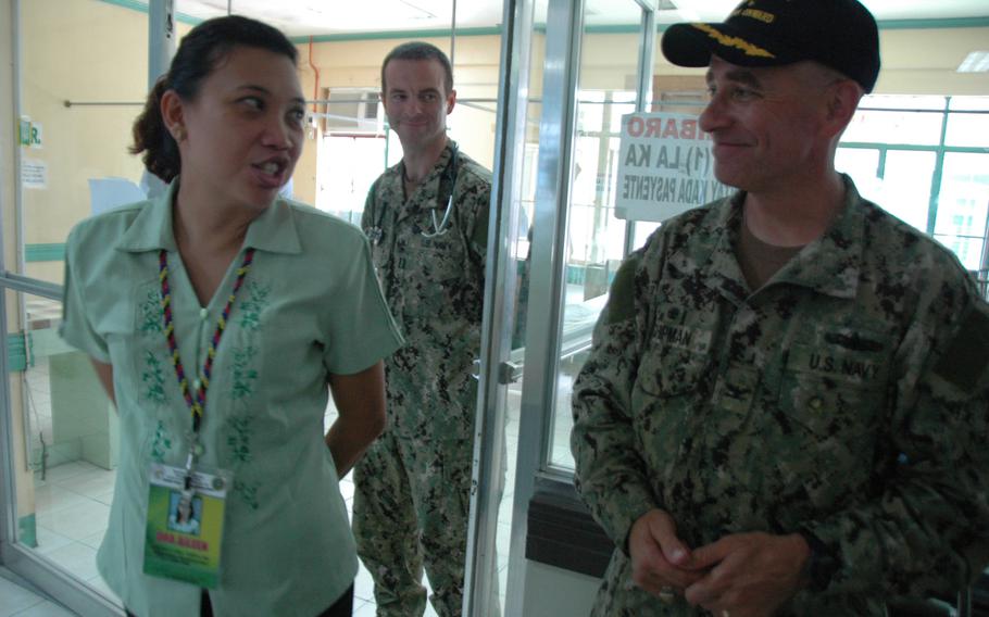 The acting director of the Eastern Visayas Regoinal Medical Center, Aileen Espina, talks to Pacific Partnership 2014 commodore, U.S. Navy Capt. Brian Shipman while Lt. Kevin Lunney, a Navy doctor, listens.