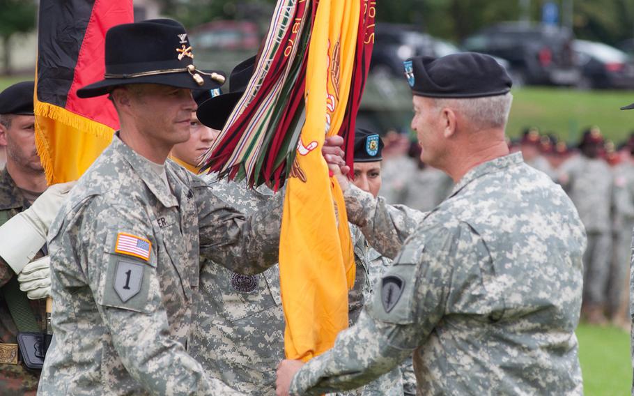 Maj. Gen. Richard Longo, deputy commanding general of U.S. Army Europe and commander of U.S. Army NATO, passes the 2nd Cavalry Regiment unit colors to its new commander, Col. John Meyer, during a change of command ceremony held at Vilseck, Germany, Tuesday, July 15, 2014.